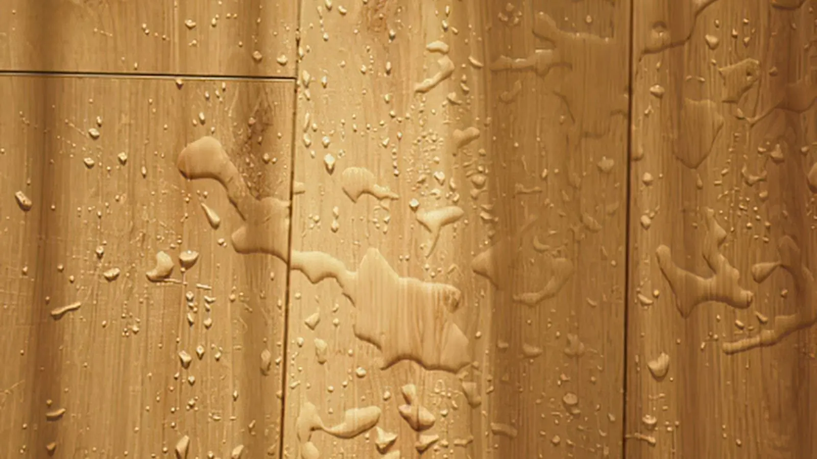 Wood plank flooring beaded with water droplets